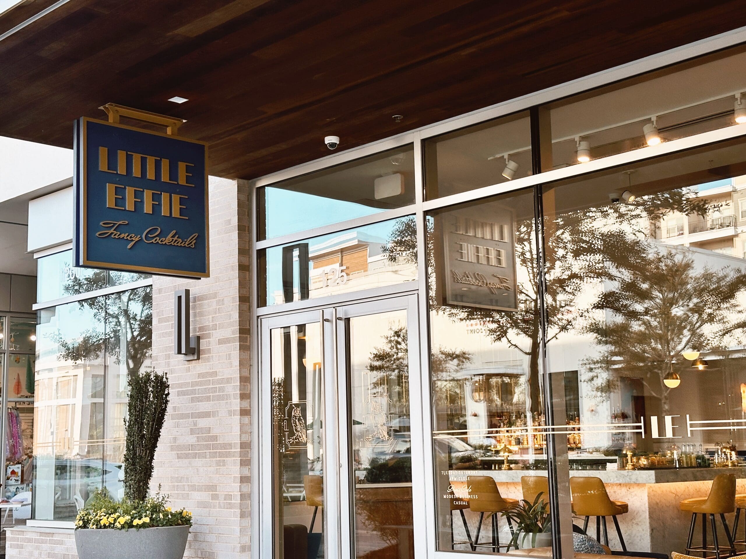 Exterior shot of Little Effie bar at The District. Glass windows reflecting the outside.